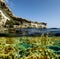 View of the cliffs and sea caves of Cape Greco from under the wa