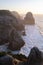 View of the cliffs and surf in the Atlantic Ocean at sunset, Miradouro da Praia do Caneiro, Portugal.