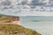 View from clifftop at a golden beach with people enjoying walking and coastline of West Bay