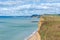 View from clifftop at a golden beach with people enjoying walking and coastline of West Bay