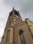 View of the clock tower and building of the historic saint peters parish church in the center of huddersfield against a cloudy sky