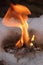 View close up closeup on fire from stone of Calcium carbide burn with big flame in white snow