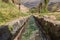 View close-up on a water canal of the ancient Inca ruins TipÃ³n, Peru.