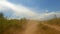 View of the clouds of dust created by a speeding car on a dry country road. Traveling by car in Kyrgyzstan