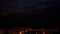 view of clouds at night over sea bay mountains and city lights