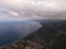 View of coast of Cala Gonone, surrounded by mountain range with green forest in Sardinia, Italy.