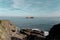 View from the coast to the Faro de la Isla de Mouro under the blue sky