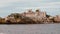 View of a coastline and abandoned house on an island, from a cruising boat on a river,