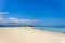 View of coastline of Iranja Island, Nosy Iranja lined with palm trees and boats floating in the sea, Madagascar