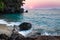 View of coastline on Nosy Komba Island lined with palm trees and boats floating in the sea at sunset, Nosy Komba