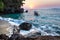 View of coastline on Nosy Komba Island lined with palm trees and boats floating in the sea at sunset, Nosy Komba