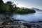 View of coastline on Nosy Komba Island lined with palm trees, Madagascar