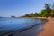 View of coastline on Nosy Komba Island lined with palm trees, Madagascar