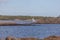 View at the coastline in Sweden a baltic sea with heavy clouds, sailboat, lighthouse and big rocks coming out of the sea