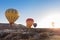 View of colorful hot air balloons flying over the Red valley on sunrise. Goreme, Cappadocia, Turkey