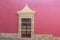 view of colorful house with pink wall and colonial window in pueblo Zimapan Hidalgo Mexico