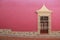 View of colorful house with pink wall and colonial window in pueblo Zimapan Hidalgo Mexico