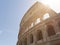 View of Colosseum with flare in a sunny day with little clouds