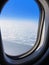 View of a commercial aeroplane from window where you can see the wing which flies above the clouds.