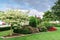 View of a composition of plants and flowers on a well-kept lawn in a public park. Concept landscape, landscape design