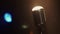 View of concert vintage microphone stay on stage under spotlight. Smoke.