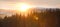 View of conifer forest covered with snow at sunset. Banner design