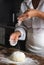 View of the cook`s desk. The photo shows the hands of the cook sprinkling flour on the dough