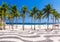 View of Copacabana beach with palms and mosaic of sidewalk in Rio de Janeiro