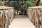 view of corridor, floor and wooden railing garden chairs and forest in the background