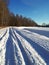 View of country road with car tracks in very deep snow