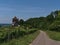 View of country road between green vineyard and forest leading to historic medieval castle Burg Wildeck in Abstatt.