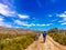 View of couple riding bicycles on a dirt road in beautiful parkland