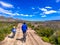 View of couple riding bicycles on a dirt road in beautiful parkland