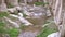 View on creek flowing among stones and ruins