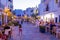 View on crowded street with cafe, bars and restaurants in old town Dalt Vila,in summer in evening illumination, Ibiza, Spain