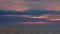 View from cruising ship in calm seas to horizon and sunset glow in sky