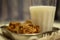 View of crunchy coconut cookies along with hot milk in a glass