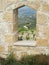 View of cypriot vineyard through hole in stone wall