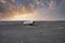 View of damaged airplane wreck at black sand beach in Solheimasandur in sunset