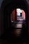 The view through the dark archway on narrow medieval Old Town street with parked motorbike near the building