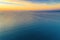 View of dawn over ocean with distant coastline.