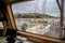 View of the deck of a ship and Kastela city of Piraeus during a rainy day through glass with water drops