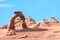 View of Delicate Arch in Arches National Park during a sunny day - bright blue sky in background