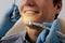 View of dentist in latex gloves holding dental instruments near cheerful patient