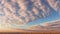 View of a desert landscape with altocumulus clouds at sunset against the blue sky