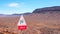 View of desert mountains with an arid landscape and a double curve road sign against a blue sky