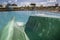 View of detail of green color a waterslide to landing in a refreshing pool in the waterpark