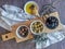 View at the different types of olives inside bowls on top of a traditional wooden base, plate with extra virgin olive oil and a