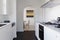 View of dining room at the end of a contemporary white galley kitchen