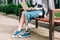 View of disabled woman sitting on bench and using laptop on street